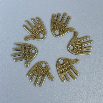 אביזרי תלייה – תליון בכף היד, עבודת יד, צבע מתכת: ברונזה, מידות 12×11×1 מ״מ ±פתח, קוטר 1.5 מ״מ ±, אריזה 20 גרם (~50 יחידות).