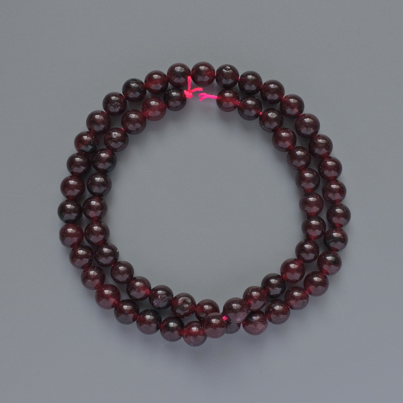 חרוזי טורמלין חלקים בצורת כדור, קוטר 6.5 מ״מ, אורך כ-38 ס״מ על החוט