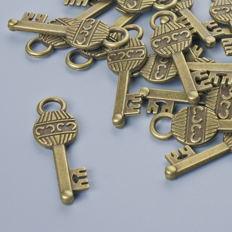 תליון «מפתח», בצבע ברונזה, קוטר 26×8 מ״מ, קוטר חור 3,5 מ״מ, גימור 16 חד׳ ±