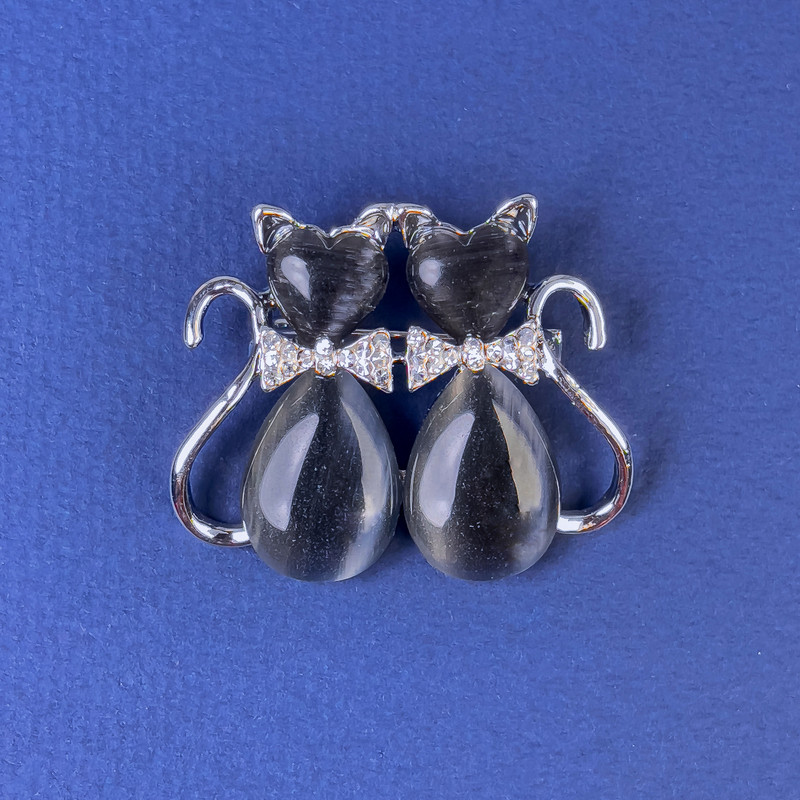 סיכת חתולים אפורה כהה עם אבן עין חתול כהה וקריסטלים לבנים, מתכת כסופה, קוטר 31×38 מ״מ +