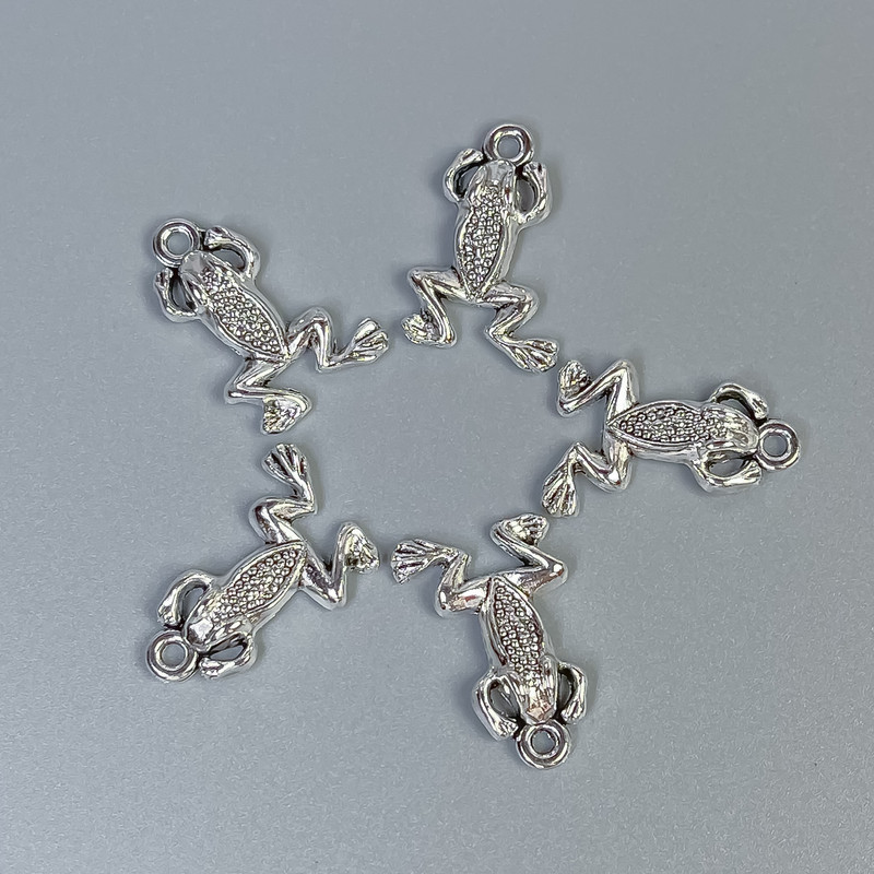 אביזרי תלייה – צפרדע בצבע כסף, מידות 20×13×3 מ״م ± פתח בקוטר 1.5 מ״م ± אריזה 20 גרם (~ 18 יחידות)