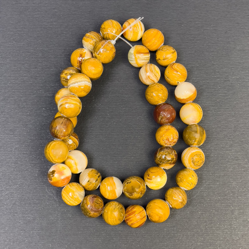 חרוזי אוניקס כדור חלק, קוטר 10 מ״מ, חור בקוטר כ-1.5 מ״מ, אורך 38 ס״מ