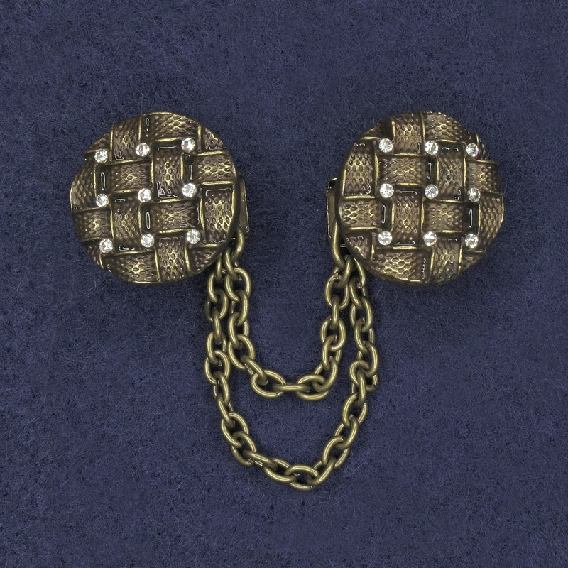 סיכת קרדייגן בצבע ברונזה עם אבני סטרז לבנות, קוטר כ-20 מ"מ ±, שרשרת באורך כ-9 ס"מ