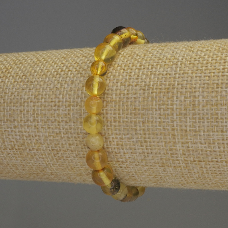 צמיד ענבר – חרוזים חלקים בקוטר 6–6.5 מ״מ, אורך 18 ס״מ, בסיס גמיש