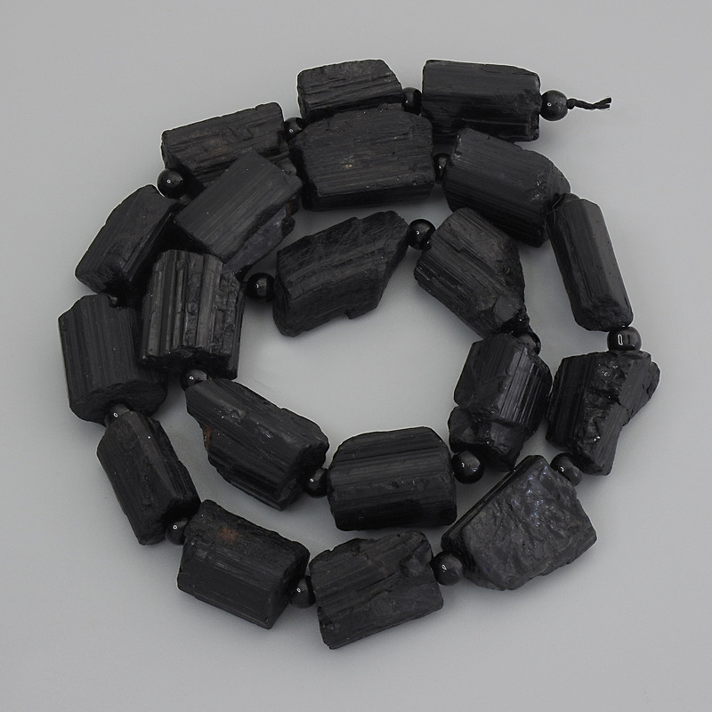 חרוזי טורמלין שרל – אבן גולמית, קוטר 15–18×10–12 מ״מ, חרוזים זעירים 4–5 מ״מ על החוט, אורך 41 ס״מ