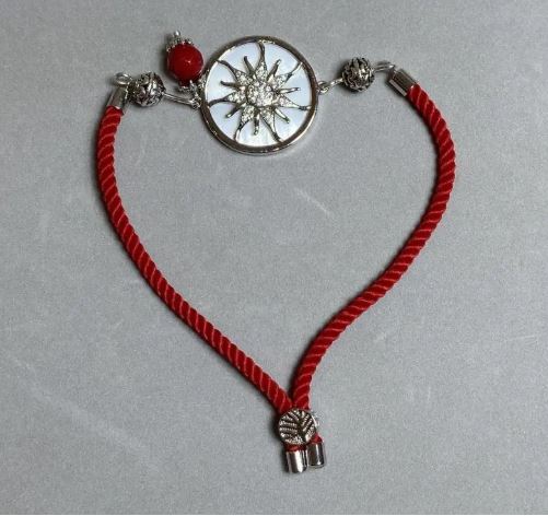 צמיד טקסטילי, קוטר 5.5 מ״מ ±, מתכוונן באמצעות קשירה, עם תוספת מתכת כסופה, קוטר 24 מ״מ ±