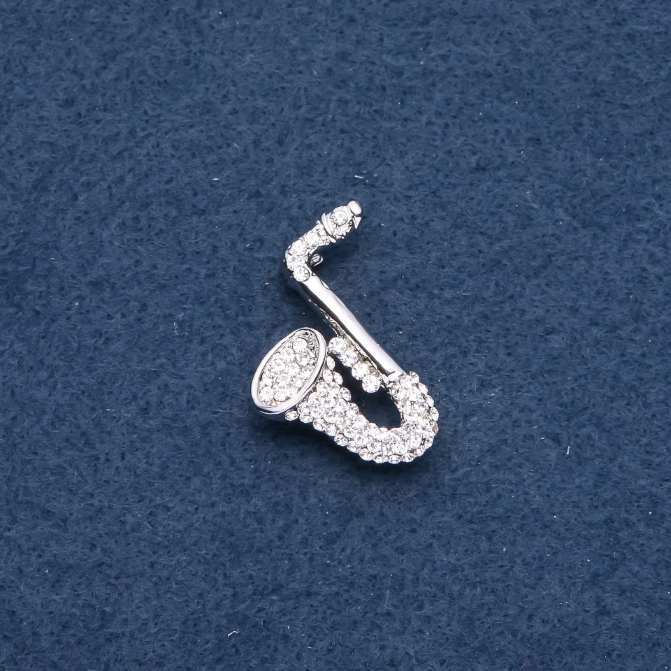 סיכה מוזיקלית «סקסופון» 28×25 מ״מ צבע המתכת: כסף