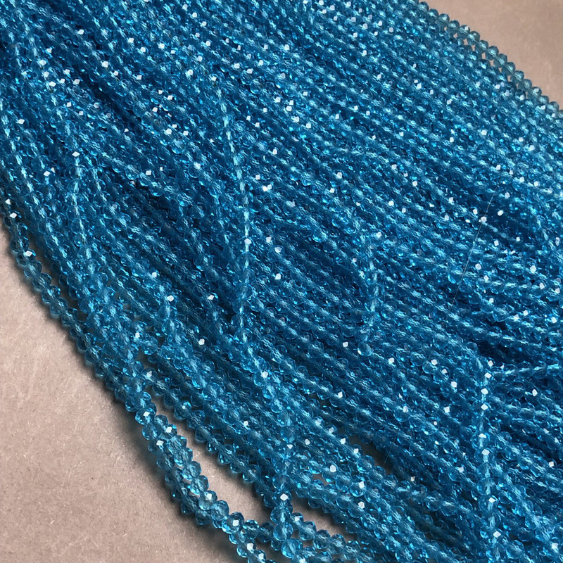 חרוזים מקריסטל צ'כיה על חוט דק בצבע כחול-ירקרק שקוף, רונדל מלוטש, קוטר 3,5×3 מ"מ +/- אורך 36-38 ס"מ +