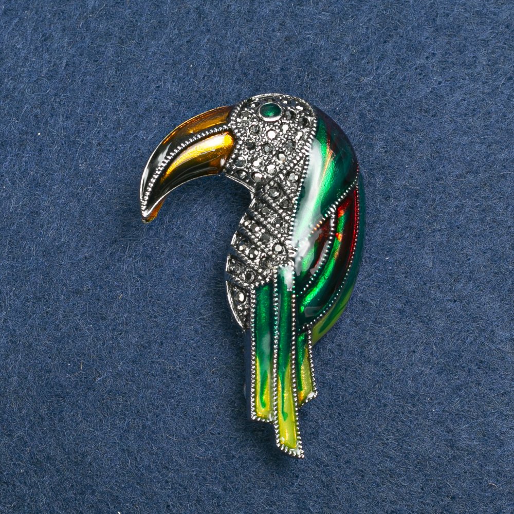 סיכה «טואקן» מתכת כסופה, אמייל וסטראזים 36×16 מ״מ +