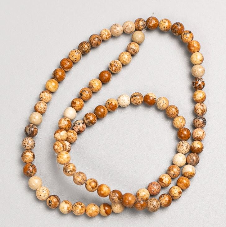 מחרוזות על חוט: אבן נוף יאשמה חלקה כדור, קוטר 4–5 מ״מ, אורך כ-37 ס״מ