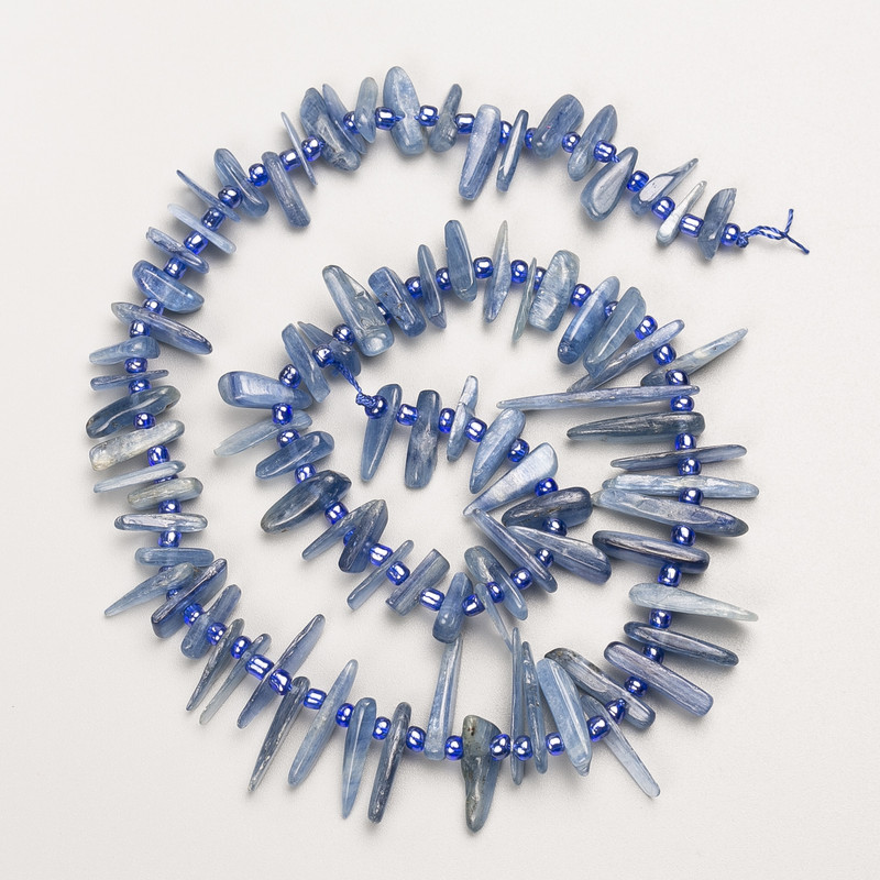 חרוזי קיאניט מאבן טבעית בצורה דקה «מחט» על חוט, קוטר 28x2-10x2 מ״מ, אורך 40 ס״מ ±, עם חרוזי זעירים, קוטר 3 מ״מ