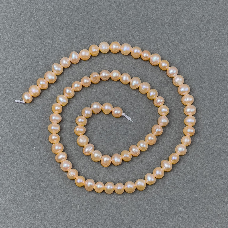 פנינים נהריות בצבע אפרסק על חוט d 5-6×5-4 מ״מ+- אורך 36 ס״מ