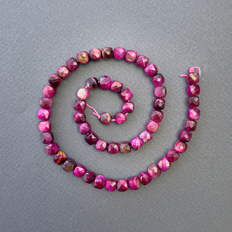 חרוזים מעין הטייגר בצבע פטל, אבן טבעית במבנה קובייתי מחורץ, קוטר 7×7 מ״מ, אורך 39 ס״מ על חוט