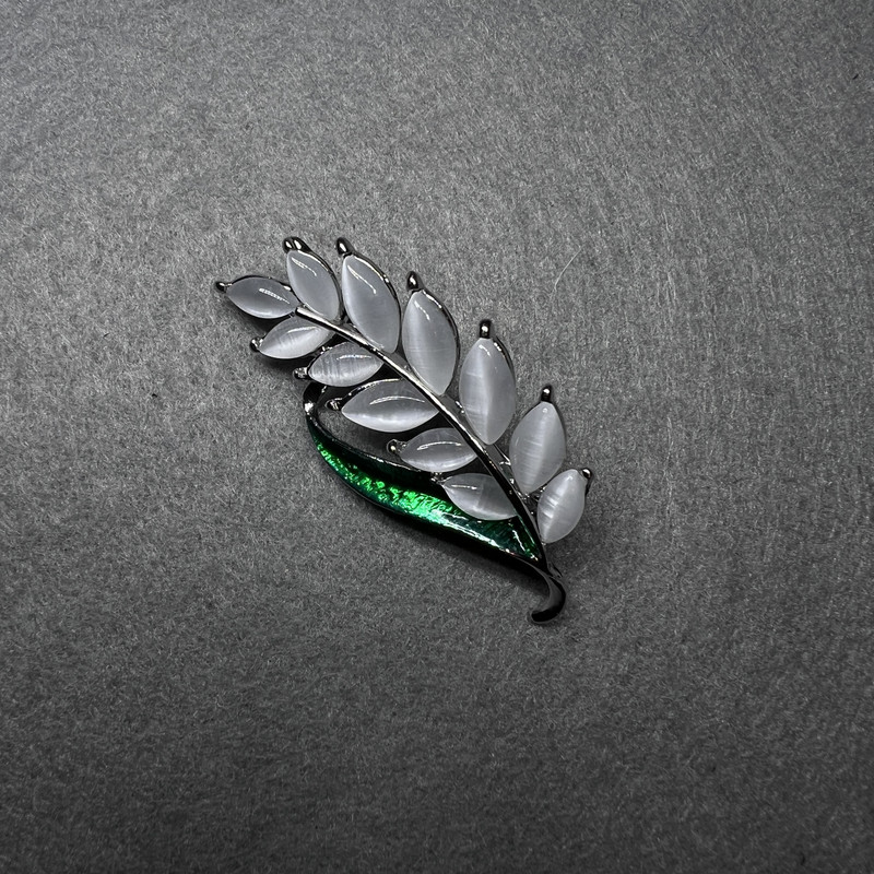 סיכת דש «ענף» עם עין חתול לבנה, אמייל ירוק ומתכת זהובה 22×47 מ״מ