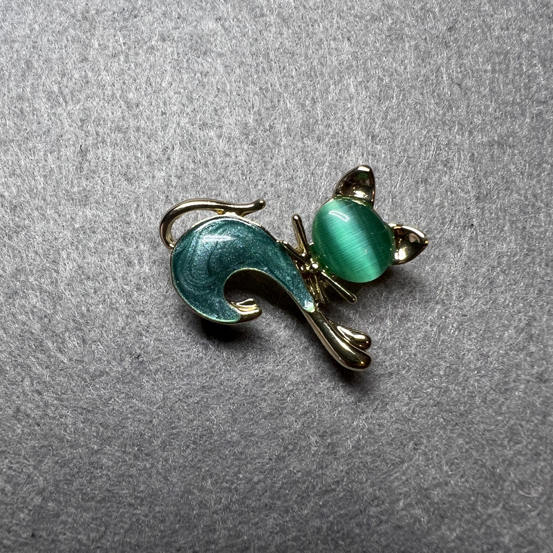 סיכת תכשיט חתלתול עם עין חתול ירוקה, אם פנינים ירוקה ומתכת זהובה 28×23 מ״מ